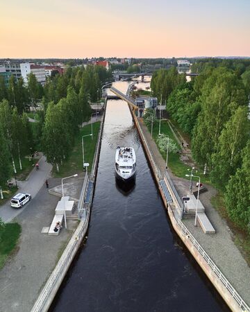 Joensuu, Finland - June 7, 2019: Aerial view of the canal in Joensuu, Finland. The ship passes the lock on the canal. The bridge over the canal is raised. Summer sunny warm day.のeditorial素材