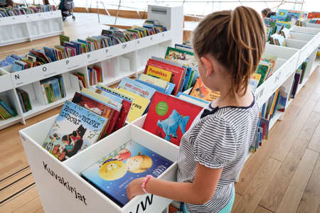 Helsinki, Finland - July 1, 2020: The girl reads the book in Oodi libraryのeditorial素材