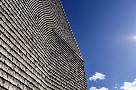 The facade of a modern wooden building on the blue sky background. Modern nordic architecture.