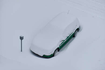 Snow-covered car on the parking place after the strong snowstormの写真素材