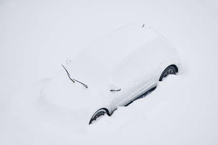 Snow-covered car on the parking place after the strong snowstormの写真素材