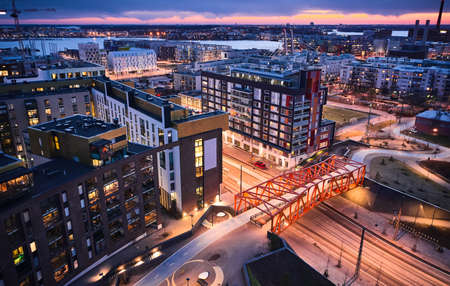 Aerial view of the modern neighborhood Jatkasaari of Helsinki, Finland. Modern Nordic architecture. Orange modern bicycle-pedestrian bridge over the street.の写真素材