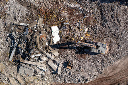 Aerial view of the excavator at the work of building demolishing. The redevelopment of the old...