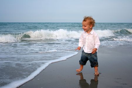 Cute boy playing at the beachの写真素材