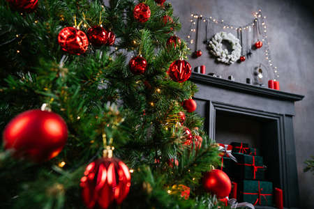 New Year 2021 interior with candles, bulbs and bokeh. Room decorated to christmas celebration. Christmas tree with presentsの写真素材