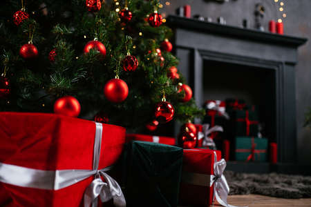 New Year 2021 interior with candles, bulbs and bokeh. Room decorated to christmas celebration. Christmas tree with presentsの写真素材