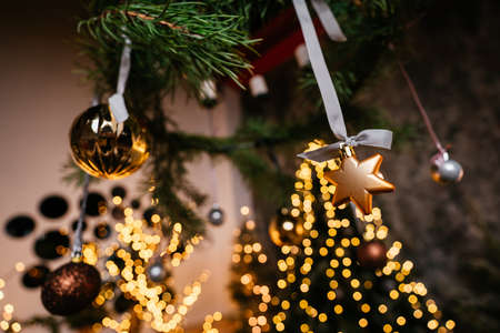 New Year 2021 interior with candles, bulbs and bokeh. Room decorated to christmas celebration. Christmas tree with presentsの写真素材