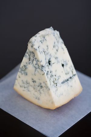 Soft Focus Aged Mountain blue cheese wedge on wax paper on a tableの写真素材