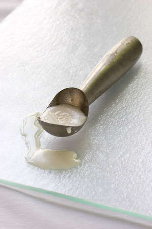 ice cream scoop with melted vannila ice cream in the scoop