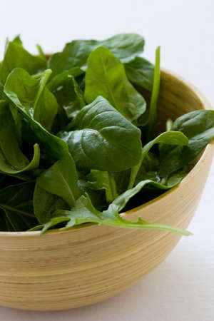 Spinach salad in a bamboo wooden bowlの写真素材