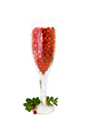 glass filled with juicy cranberries with leavesの写真素材