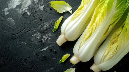 Fresh raw Belgian endives (chicory) on black table, closeup.の素材