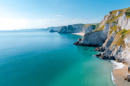 Aerial view of turquoise sea washing sandy beach and white cliffs in Pembrokeshire Coast National Park, Wales, United Kingdomの素材