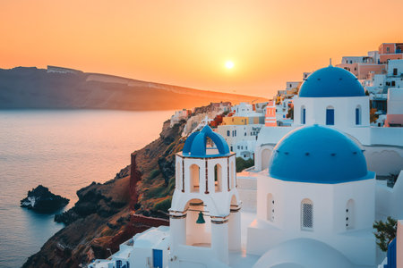 Beautiful sunset over the caldera in Oia, Santorini, Greece, with white and blue domed churchesの素材