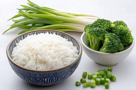 Bowls of steamed rice, broccoli florets and chopped spring onions offer a simple yet nutritious and healthy meal optionの素材