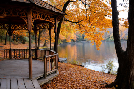 Serene autumn landscape featuring a wooden gazebo by a tranquil lake, surrounded by trees in vibrant fall colorsの素材