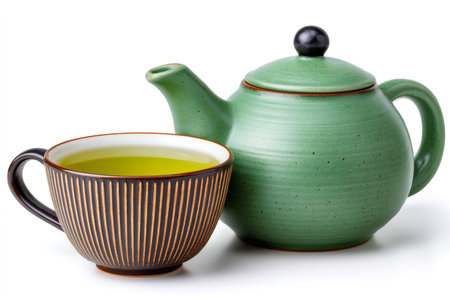Green tea pouring into a cup from a natural ceramic teapot for a hot refreshing drinkの素材