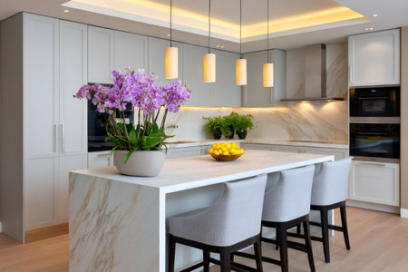 Contemporary kitchen design with a marble island, bar stools, integrated appliances, and decorative orchidsの素材