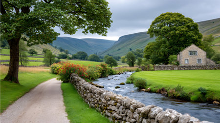 Green pastures and a winding river flow through a scenic valley, showcasing traditional stone architectureの素材
