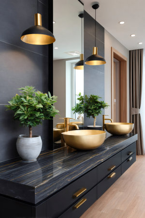 Bathroom vanity with black cabinetry, gold sinks, gold faucets, and pendant lights reflecting in mirrorの素材