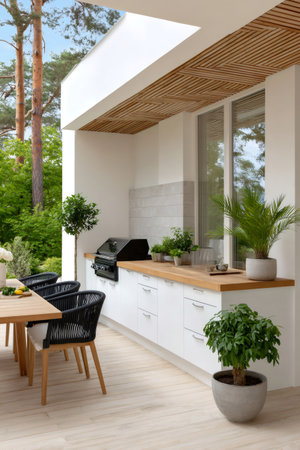 Contemporary backyard patio featuring an outdoor kitchen, barbecue grill, and wooden dining tableの素材