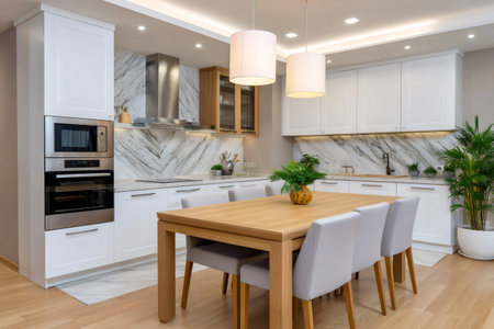 Contemporary kitchen and dining area featuring white cabinets, wooden table, and marble backsplashの素材