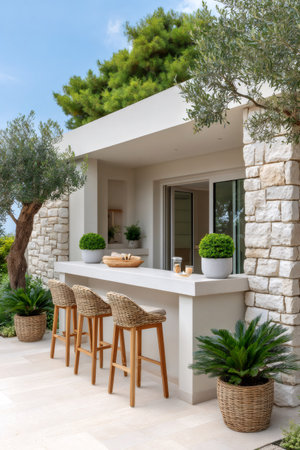 Outdoor bar with wicker stools, stone walls, olive trees, and potted plants on a patioの素材