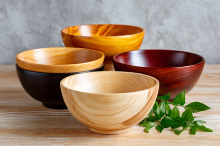 Grouping empty wooden bowls of various colors and sizes, ready for food preparation or servingの素材