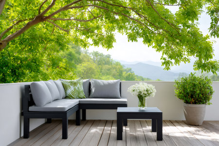 Outdoor lounge furniture on a modern deck offering a serene mountain and forest viewの素材