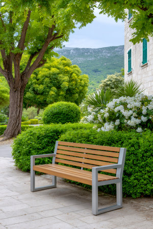Modern park bench inviting relaxation in a lush green garden with a mountain landscapeの素材