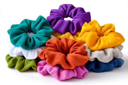 Assortment of vibrant scrunchies stacked on a plain white background, highlighting fashion accessoriesの素材