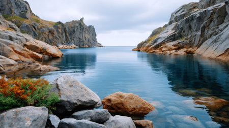 Serene ocean inlet featuring massive rock formations and shallow clear blue waterの素材