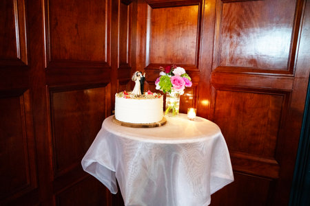 Wedding cake with flowers and candles on a table in a restaurantの写真素材