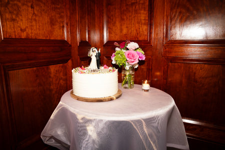 Wedding cake with bride and groom on the table in a restaurantの写真素材