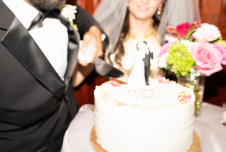 wedding cake on table in restaurant with blurred groom and brideの写真素材