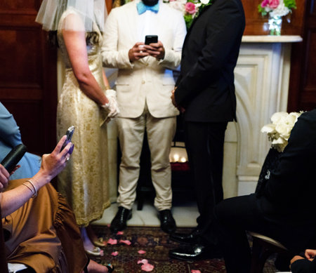 Wedding couple using mobile phones during a wedding ceremony in a churchの写真素材