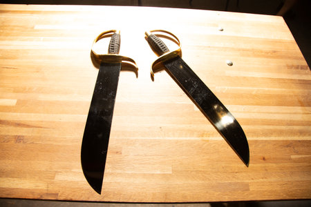 Medieval sword on a wooden table, closeup of photo.の写真素材