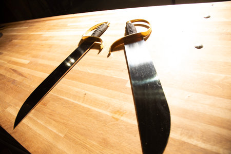 Closeup view of a pair of knives on a wooden table.の写真素材