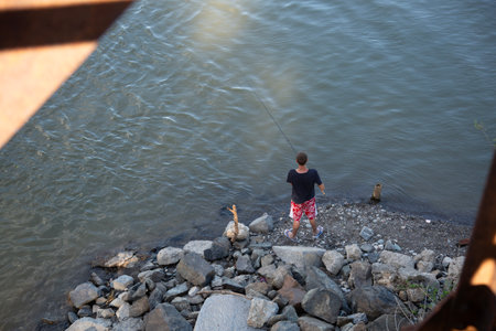 Boy fishing on the river bank. The concept of a healthy lifestyle.の写真素材