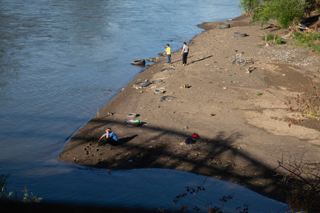 Unidentified people rest on the bank of the river.の写真素材