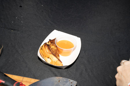 Close-up of grilled cheese sandwich and cup of soup on black backgroundの写真素材