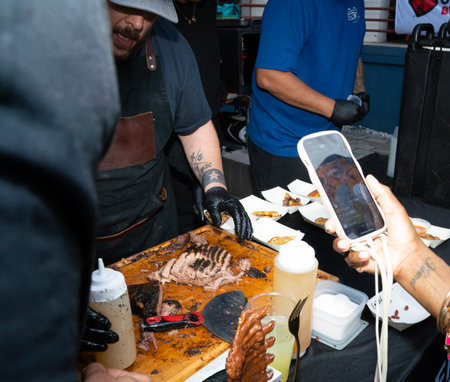Unidentified people take photo of grilled steak in a street food market.の写真素材