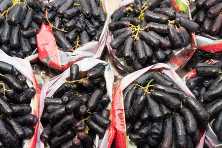 Black grapes in plastic bags on a market stall.の写真素材