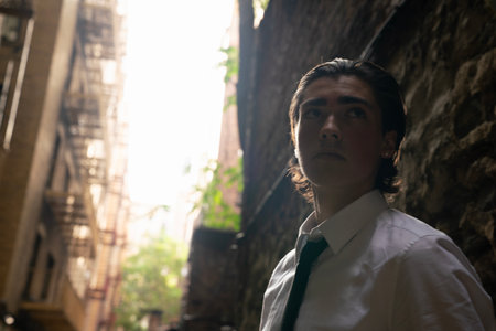 Portrait of a young man standing in an old building with a serious expressionの写真素材