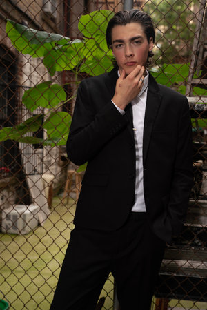 Portrait of a handsome young man in a black suit and white shirtの写真素材