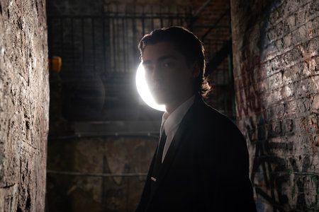 Portrait of a young man in a black suit in an abandoned buildingの写真素材