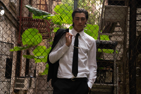Young handsome Asian businessman wearing white shirt and black tie posing in the street.の写真素材
