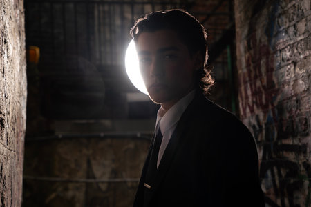 portrait of a young man in a dark room with a lampの写真素材