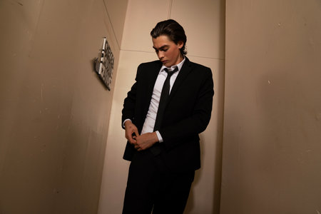 Portrait of a handsome young man in suit posing in the roomの写真素材