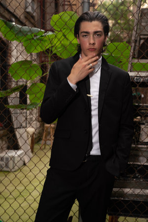 Handsome young man in a black suit with a beautiful hairstyleの写真素材